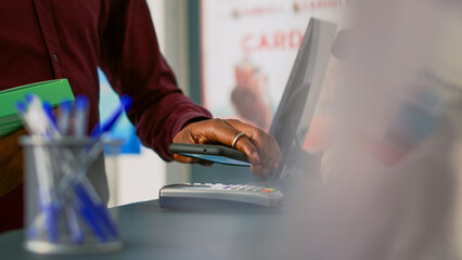 Clients buying pharmaceutical products at cash register desk, paying with smartwatch, mobile phone with nfc and credit card. Customers having pills and medicaments at counter. Close up. Tripod shot.