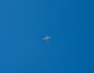 Jet privado volando en cielo completamente azul, avión.