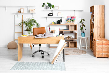 Interior of modern atelier with tailor's workplace and shelving units