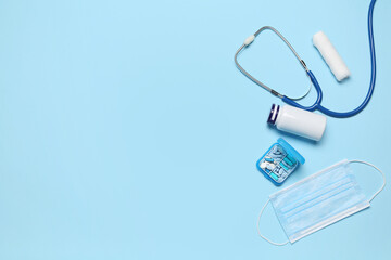 Obraz premium Stethoscope with pills and medical mask on blue background. World Health Day
