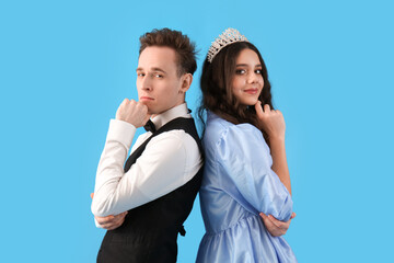 Thoughtful couple dressed for prom on blue background © Pixel-Shot