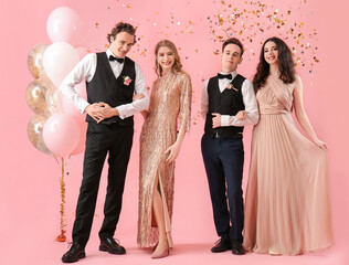 Beautiful couples dressed for prom on pink background © Pixel-Shot