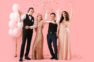 Beautiful couples dressed for prom on pink background © Pixel-Shot