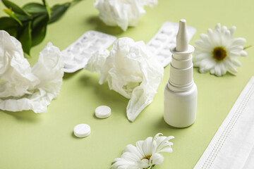 Obraz na płótnie Canvas Nasal drops with pills, flowers and tissues on green background, closeup. Seasonal allergy concept