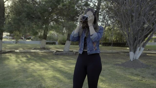 Young Woman Capturing the Perfect Shot in the Park