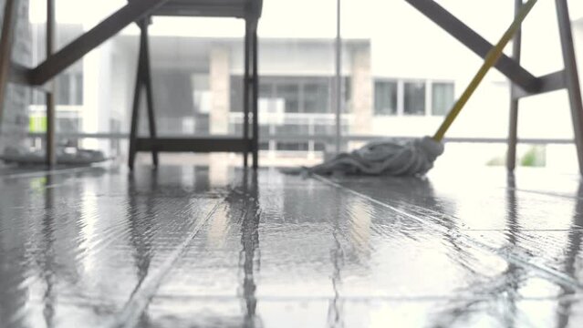 Unrecognizable person cleaning floor with rope mop. Closeup