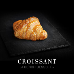 Side view of traditional French croissant isolated on black background. Ready square menu banner with text and copy space. Fresh dessert on top served on slave board