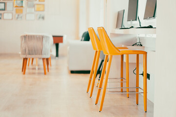 A bright yellow padded chair for typing in the computer in the internet room