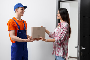 Woman receiving parcel from courier at home