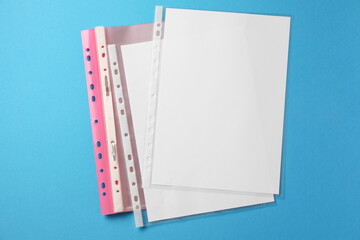 File folder with punched pockets on light blue background, flat lay