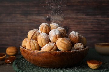 Bowl of delicious nut shaped cookies with boiled condensed milk on wooden table