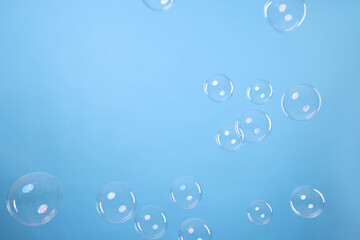 Many beautiful soap bubbles on light blue background. Space for text