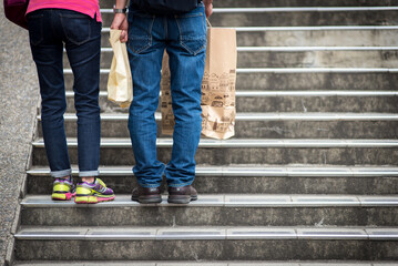 Young couple with shopping bags standing in middle of steps