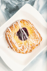 Mouth-watering blueberry and custard danish topped with white fondant and icing sugar.