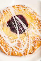 Mouth-watering blueberry and custard danish topped with white fondant and icing sugar.