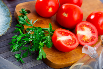 Fresh ripe tomatoes ready for cooking on wooden background at kitchen