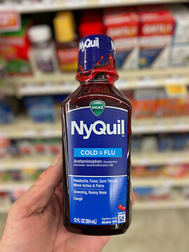 Grocery store hand holding Grocery store NyQuil cold and flu medicine