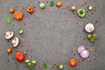 The ingredients for homemade pizza set up on dark stone background.