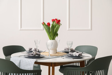 Table setting for International Women's Day celebration with tulip flowers in light room