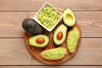 Board with delicious avocado toasts on brown wooden background