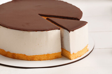 Sweet birds milk cake on light wooden table, closeup