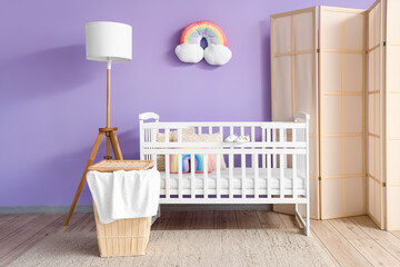 Interior of children's bedroom with crib, basket and lamp