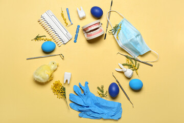 Frame made of dentist's tools, Easter eggs, chicken and flowers on yellow background