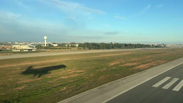 Unique pilot point of view during a jet landig at the runway , with the side view of the shadow of the plane. Afternoon light.