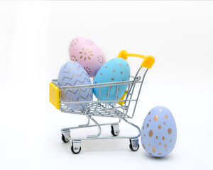 Colorful easter eggs in shopping cart on grey background. Copy space.