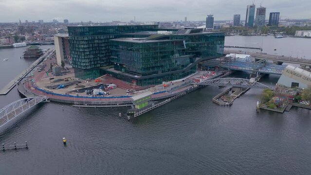 Modern corporate Building next to the amsterdam canal aerial drone shot