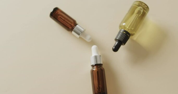 Close up of three glass bottles with pumps with copy space on beige background with copy space