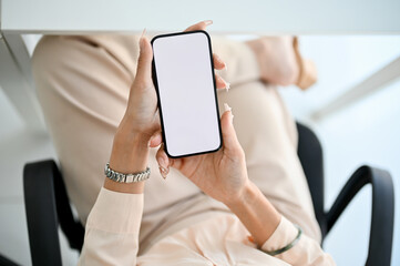 Top view of a smartphone mockup for display your graphic is in a businesswoman's hands.