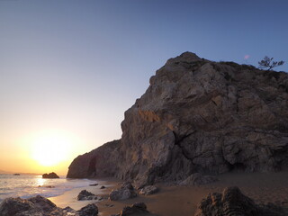Fototapeta na wymiar 巨大な岩と夕焼けの空