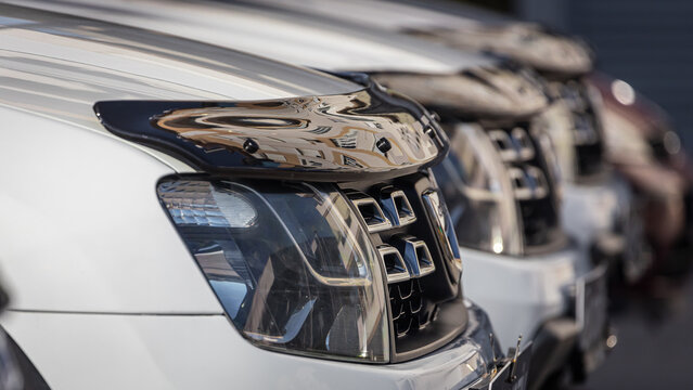 close-up of a car dealership rows of urban crossovers for sale, rear view