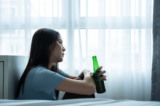 Asian young depression woman feeling heart broken and drinking beer. 