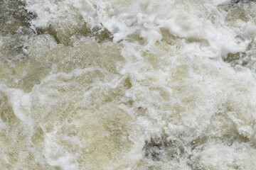 Splashing water in a turbulent stream.  Very dynamic, active and forceful. Good for a background or wallpaper.