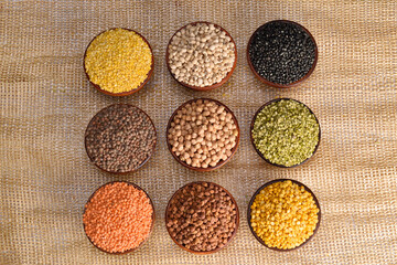 Top view of multiple lentils, seeds and gram black gram, red lentils, masoor dal, green mung beans,...