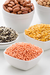 Raw masoor dal in bowl on white background, uncooked red lentils