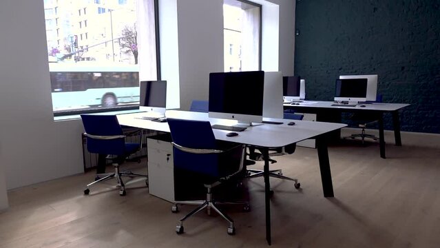 empty office with no employees. room with workplace and blue chairs, computers on white table.