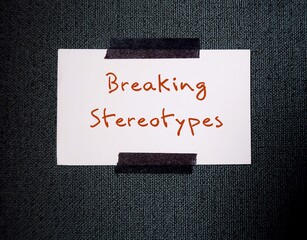 White card stick on office wall background with text message - BREAKING STEREOTYPES to stop...