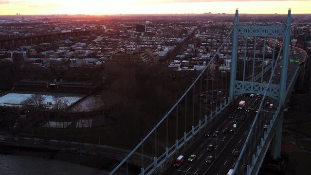Aerial view over traffic on the Robert F. Kennedy Bridge, sunny evening in New York, USA - circling, drone shot