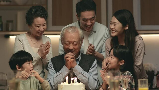 happy senior asian man celebrating birthday with three generation family at home