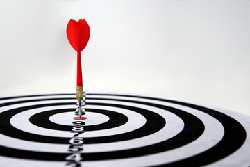 Close red dart on target board right frame. The red dart hit the target. Success and victory in...