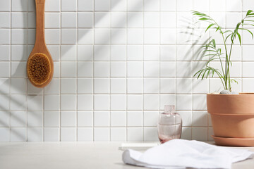 Various objects on a white tile background with warm sunlight shining through
