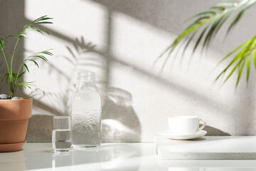 Various objects on a white tile background with warm sunlight shining through
