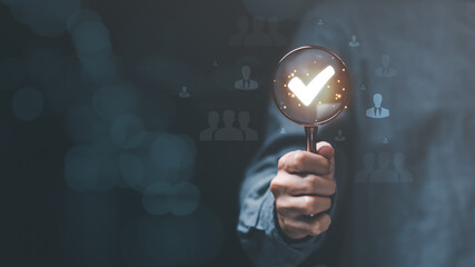 concept of business development with personnel ,Choosing a professional leader ,recruitment ,HRM or Human Resource Management ,corporate executive holding a magnifying glass and a check mark icon , © chaylek