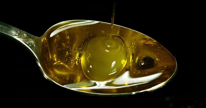 Green Olive, Olea europaea, Falling in a Spoon against Black Background, Slow Motion 4K