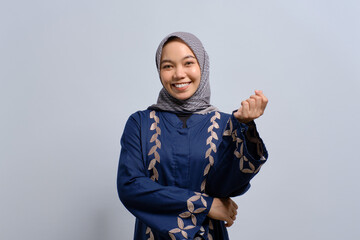 Smiling young Asian Muslim woman looking at camera feeling confident and happy isolated over white background