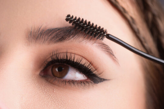 Close up eyebrows with eyebrow brush. Care for brows, eyebrows lamination. Brow procedures. Long eyelashes, eyebrows, macro.