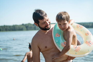 Father carry son out from lake after swimming